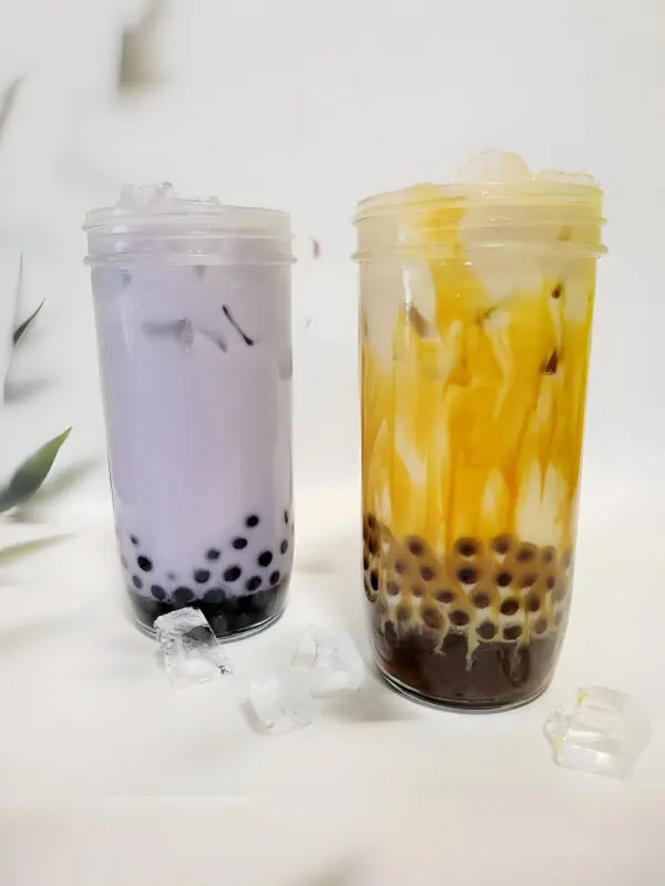 Two drinks placed on the floor with ice cubes