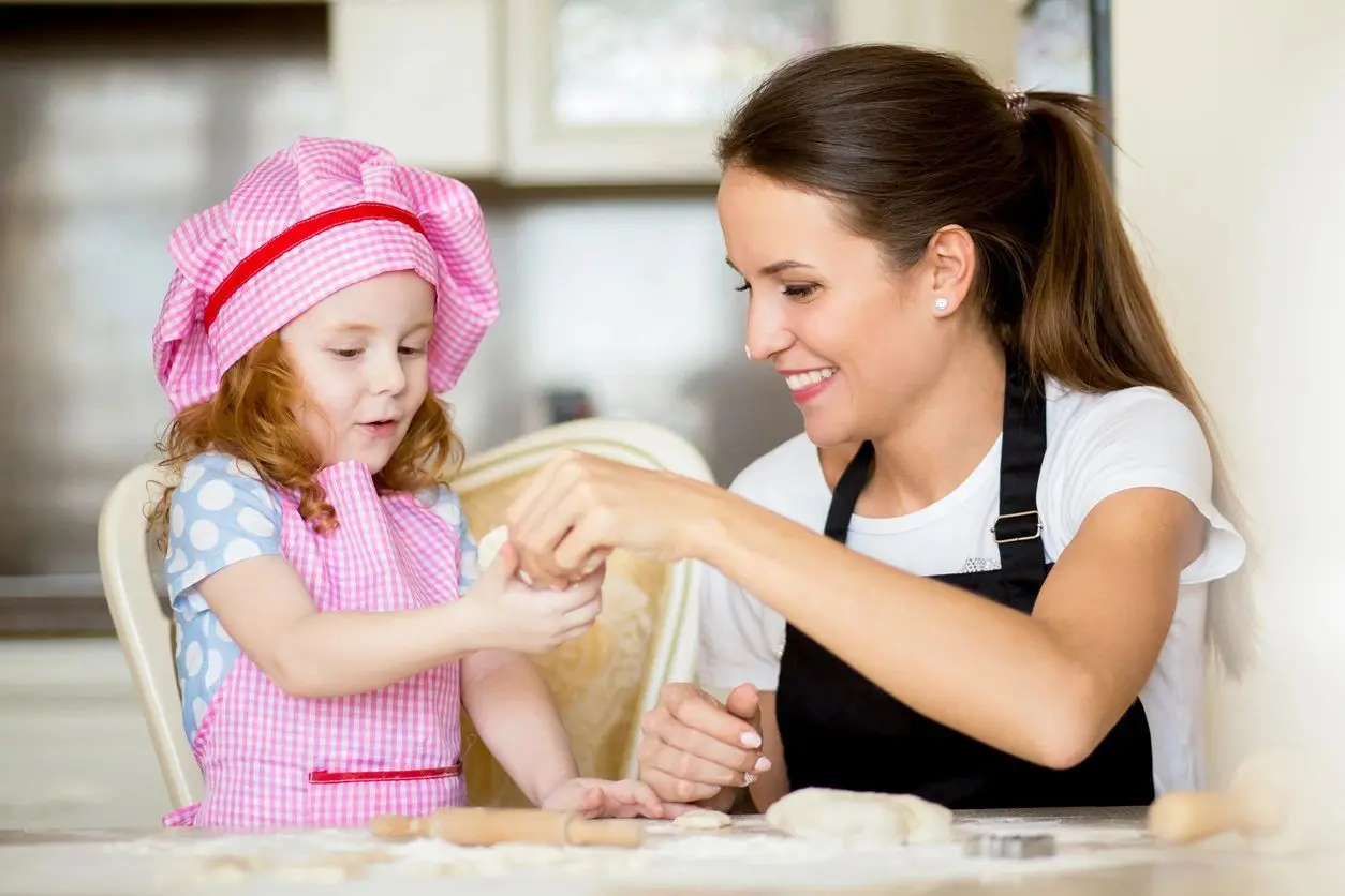 A woman and child are making cookies together.